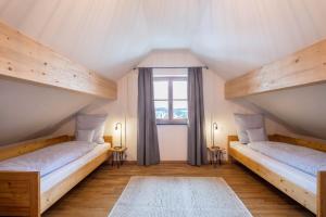 two beds in a room with a window at Ferienwohnung Josef in Gilching