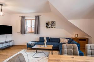 a living room with a blue couch and a tv at Ferienwohnung Josef in Gilching