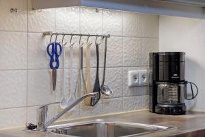 a kitchen sink with utensils hanging on a wall at Gästehaus Himmelswiese Ingo Reetz in Schönwald +114 photos
