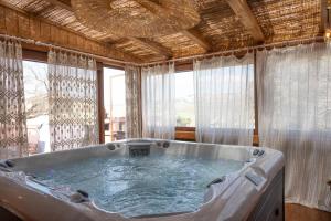 a large bath tub in a room with windows at Tuscan Retreat Private Spa Villa in Lucignano +26 photos