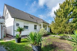 a white house with plants in the yard at Ferienwohnung im Ländlichen Raum in Reuthen