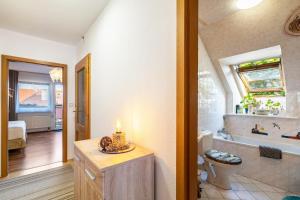 a bathroom with a tub and a toilet and a sink at Ferienwohnung im Ländlichen Raum in Reuthen +16 photos