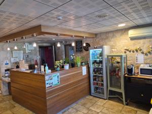 a coffee shop with a counter and a refrigerator at Les Étoiles Du Forez in Montbrison