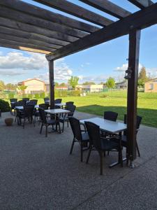 a group of tables and chairs under a pergola at Les Étoiles Du Forez in Montbrison