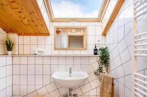 a bathroom with a sink and a skylight at Stadt-Loft mit Dachterrasse in Nordhausen +29 photos