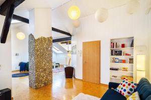 a living room with a blue couch and a stone pillar at Stadt-Loft mit Dachterrasse in Nordhausen