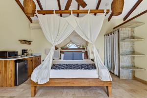 a bedroom with a bed with a mosquito net at Ocio Villas Mal Pais in Santa Teresa Beach