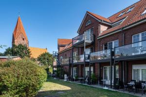 an apartment building with a balcony and a church at Ferienwohnung Am Salzhaff B6 in Rerik