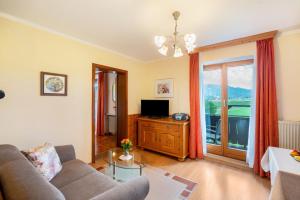a living room with a couch and a television at Ferienwohnung 3 in Grassau