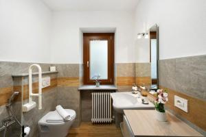 a bathroom with a white toilet and a sink at Agriturismo La Grange in Pont-Saint-Martin +63 photos