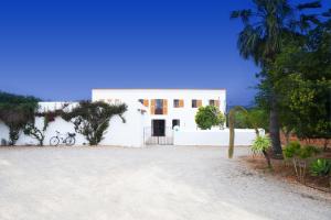 a white house with a bike parked in front of it at Can Murenu in Sant Joan de Labritja