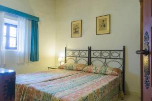 a bedroom with a bed with a bedspread on it at Can Murenu in Sant Joan de Labritja