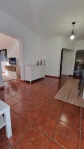 a room with a red tile floor and a white wall at Retiro do Viajante in Penacova