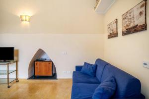 a living room with a blue couch and a tv at Conchiglia, borgo dei pescatori in Cervo