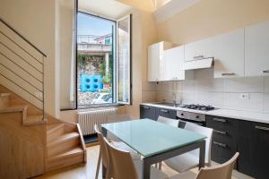 a kitchen with a table and chairs and a window at Conchiglia, borgo dei pescatori in Cervo +8 photos