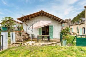 a house with a table and an umbrella at Maison de Campagne in Gignac