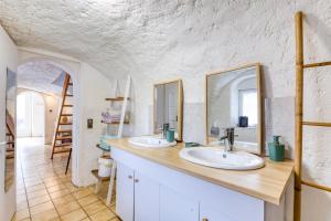 a bathroom with two sinks and a mirror at Maison de Campagne in Gignac +16 photos