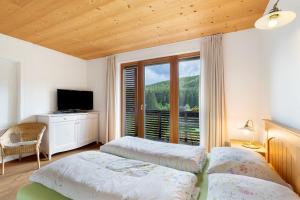 a bedroom with two beds and a large window at Silbernagl - Monolokal mit Ausblick in Issengo