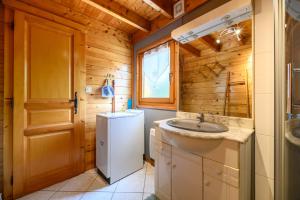 a bathroom with a sink and a refrigerator at Notre chalet in Vecoux +15 photos