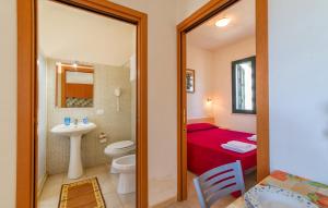 a bathroom with a toilet and a sink and a bed at Lilybeo Village - Camping & Residence in Marsala