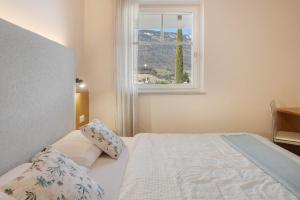a bedroom with a bed and a window at Landhaus Antonius Eppan in Appiano sulla Strada del Vino