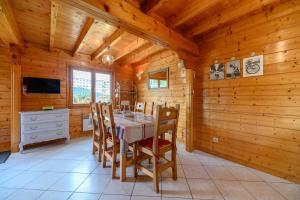 a dining room with a table and chairs in a cabin at Notre chalet in Vecoux