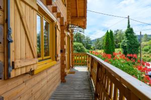 a wooden walkway next to a building with flowers at Notre chalet in Vecoux