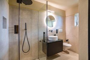 a bathroom with a shower with a sink and a toilet at Kraidlhof Designapartment Isabel in Cortaccia +17 photos