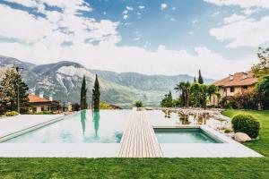 a swimming pool in a yard with mountains in the background at Kraidlhof Designapartment Isabel in Cortaccia