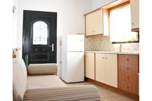 a kitchen with a black door and a white refrigerator at Manolika Studio 4 in Kithnos
