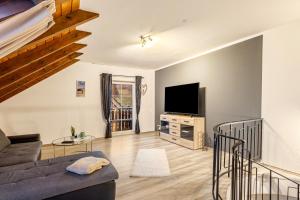 a living room with a couch and a tv at Ferienwohnung Rinke in Schmallenberg