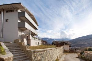 a house on a hill with a stone wall at Residence soleluna - Loft Sirio in Roisan