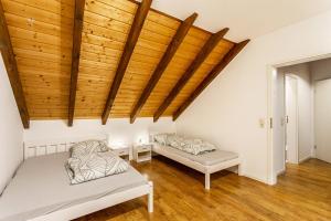 two beds in a room with wooden ceilings at Ferienwohnung Rinke in Schmallenberg