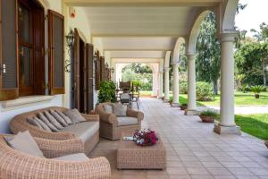 an outdoor patio with wicker furniture on a house at Tenuta Il Carretto in Monteroni di Lecce