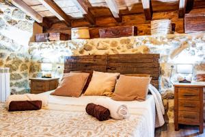 a bedroom with a large bed in a stone wall at La Cantina in Villar de Corneja