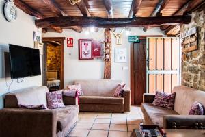 a living room with couches and a flat screen tv at La Cantina in Villar de Corneja