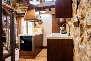 a kitchen with a sink and a stove at La Cantina in Villar de Corneja