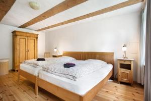 a bedroom with a large bed with white sheets at Pommernhuus an de Kark in Süderholz