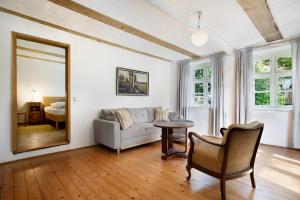 a living room with a couch and a mirror at Pommernhuus an de Kark in Süderholz