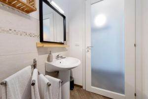 a white bathroom with a sink and a mirror at Il Gelsomino in Castro +12 photos