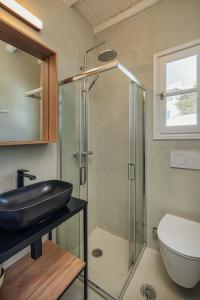 a bathroom with a glass shower and a sink at Bella Vista Vacation House in Serifos Chora