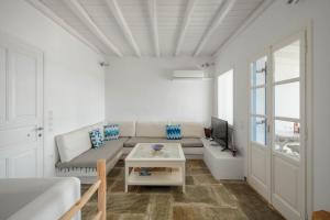 a white living room with a couch and a table at Bella Vista Vacation House in Serifos Chora +21 photos