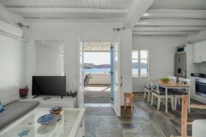 a white living room with a kitchen and a table at Bella Vista Vacation House in Serifos Chora