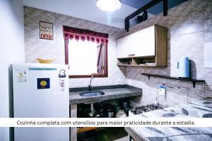 a kitchen with a refrigerator and a sink at Chalé Kamala com quintal - Perfeito para Nômades Digitais in Pipa