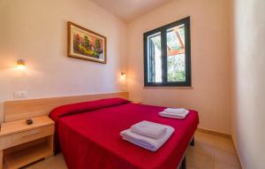 a small bedroom with a red bed and a window at Lilybeo Village - Camping & Residence in Marsala