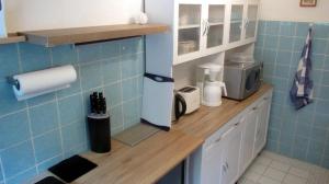 a kitchen with blue tiled walls and a counter top at Fewo Deister Bikertraum in Wennigser Mark