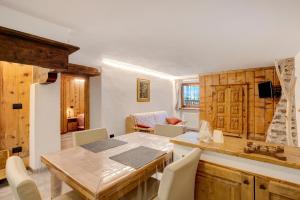 a kitchen and dining room with a wooden table and chairs at Les Cles - Genepy in Valsavarenche