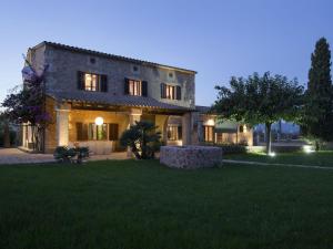 a large stone house with a green yard at night at Es Pouet in Binissalem