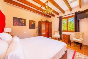 a bedroom with a large white bed and a chandelier at Es Pouet in Binissalem +32 photos