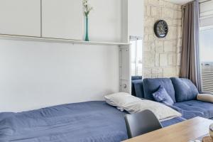 a living room with a blue couch and a table at Ventana Loft in Empuriabrava